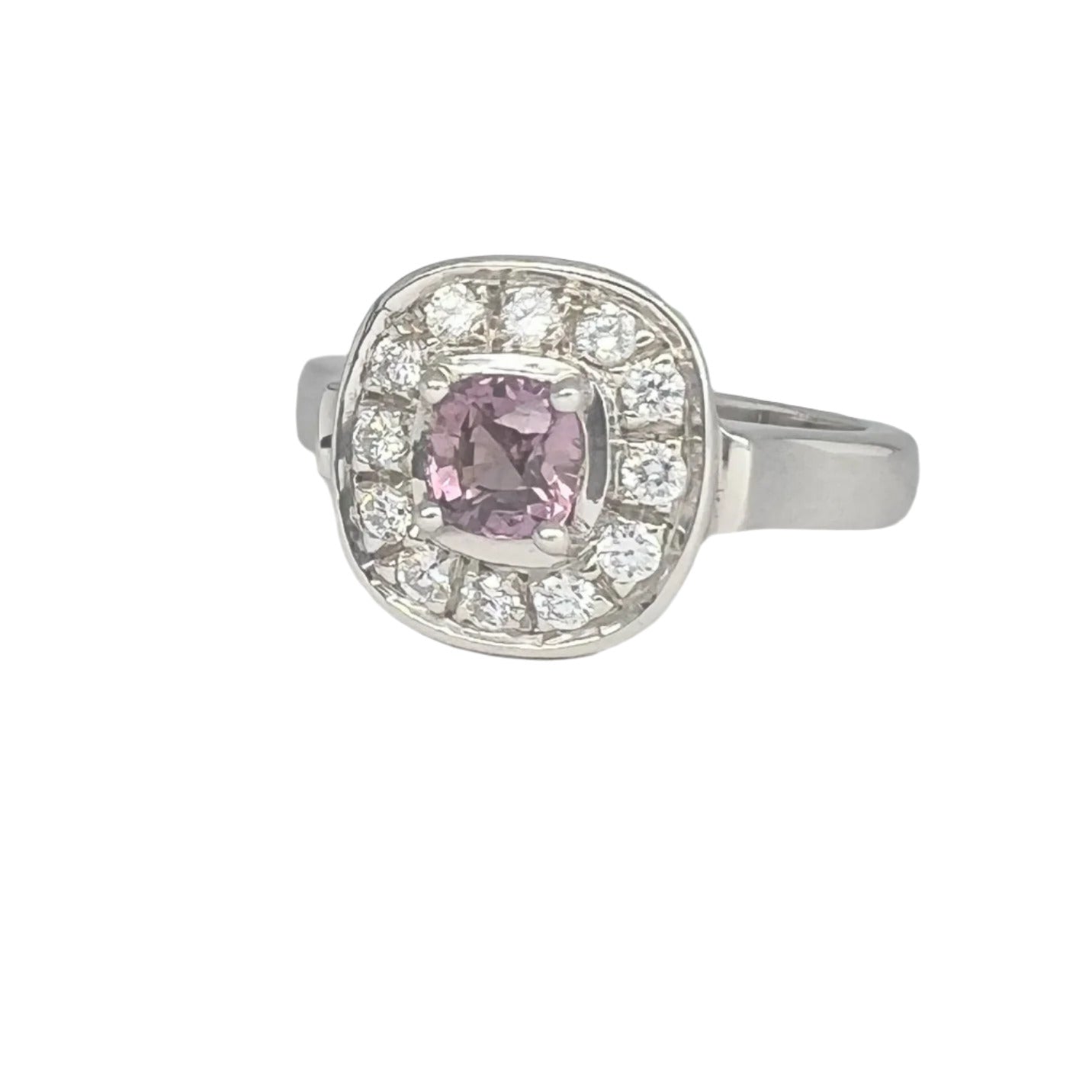 Pink sapphire engagement ring in platinum silver with cushion-cut center and diamond halo. A luxurious and unique jewelry piece for any occasion.