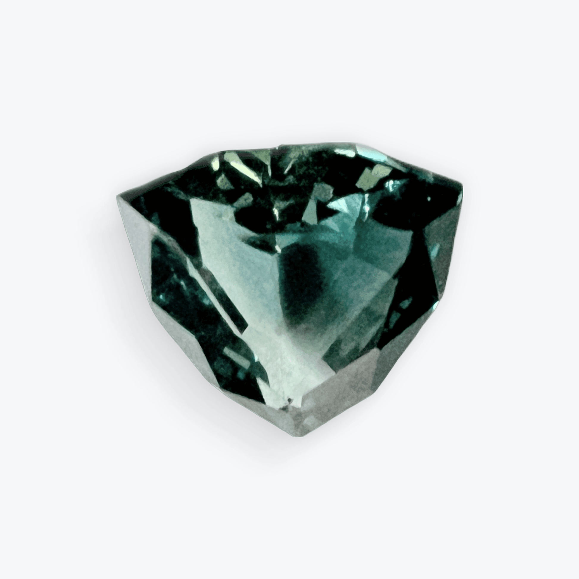 A faceted trillion cut teal blue sapphire gemstone, displaying its unique shape and rich color against a white background.