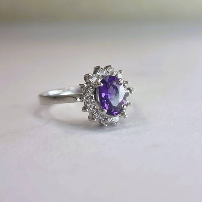 Side view of a 2.0ct oval purple amethyst and white zircon ring, highlighting its intricate setting and platinum-coated sterling silver band.