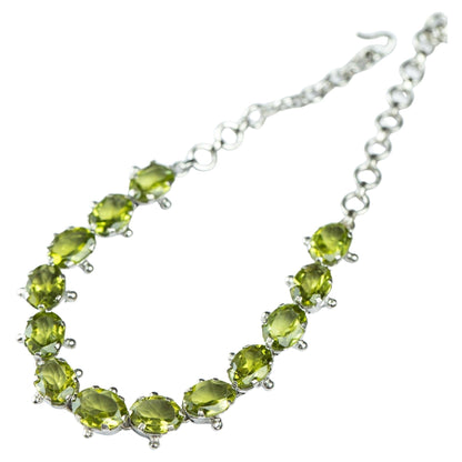 13ctw Mint Green Peridot Tennis Bracelet with oval-cut gemstones set in sterling silver. Adjustable chain for a perfect fit, ideal for elegant wear.
