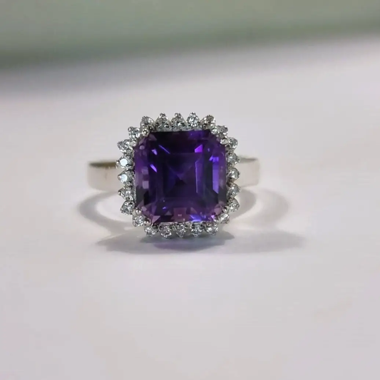 a ring with an amethorate surrounded by diamonds