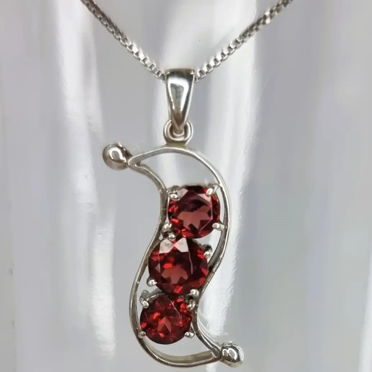 a silver necklace with two red stones on it